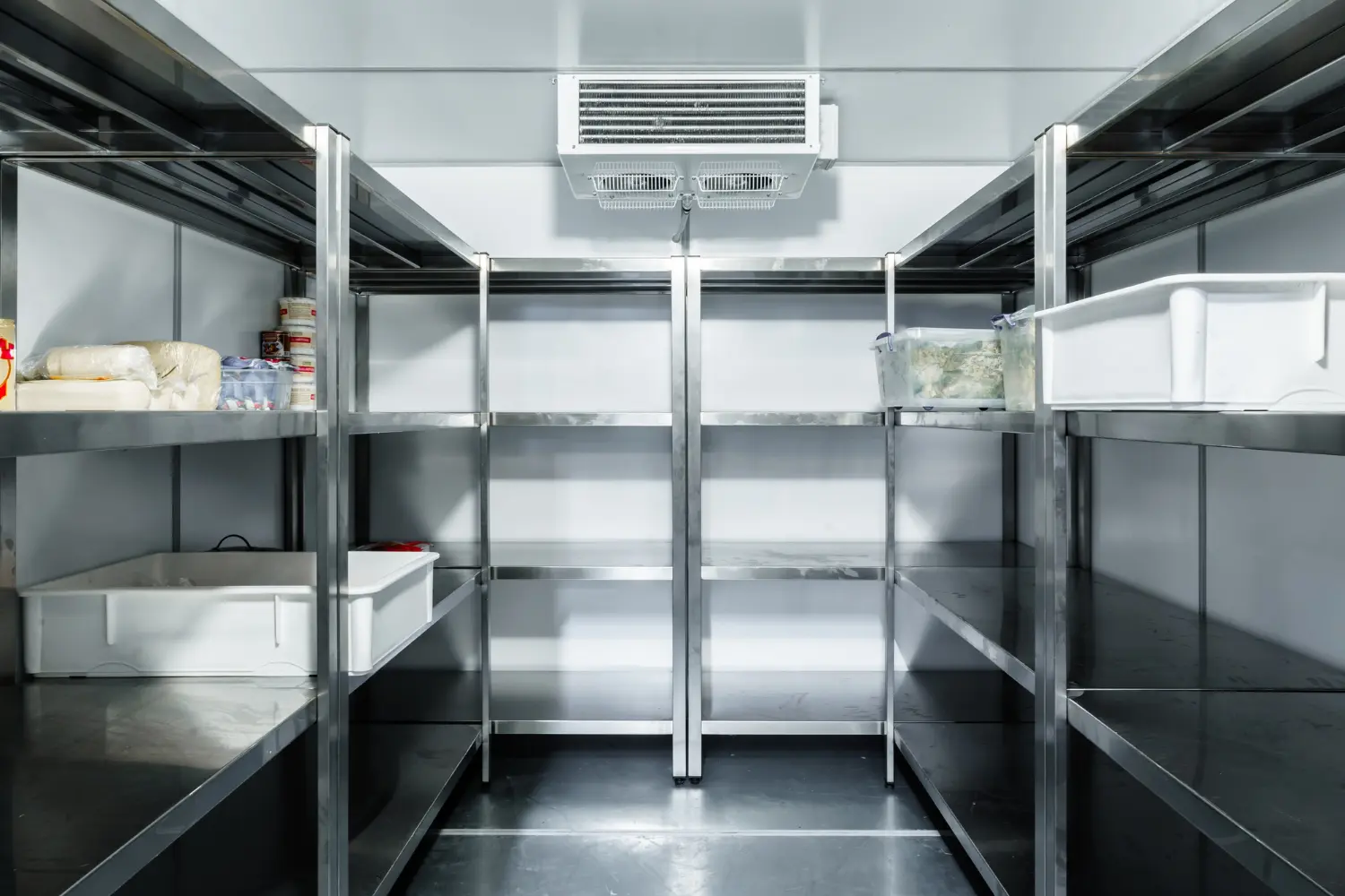 Chambre froide professionnelle avec étagères inox et groupe frigorifique au plafond